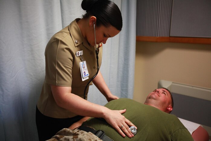 Petty Officer 2nd Class Sarah A. E. Lowe, a Naval Health Clinic Cherry Point corpsman, checks a Marine at the Naval Health Clinic here April 8. Lowe used the Navy-Marine Corps Relief Society in 2008 when she was eight and a half months pregnant and her engine block cracked. The relief society provided her with an interest-free loan.