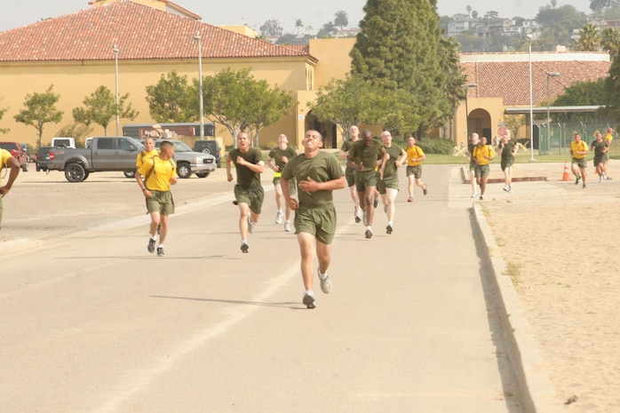 Recruits of Company H, 2nd Recruit Training Battalion, push hard to the finish line with some motivation from their drill instructors during the Physical Fitness Test aboard Marine Corps Recruit Depot San Diego March 29. For some, the three-mile run is considered by some the toughest portion of the PFT.
