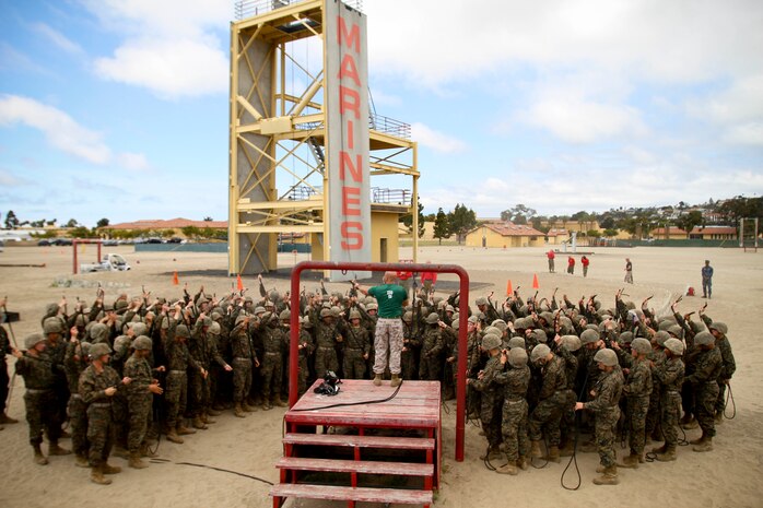Recruits of Company B, 1st Recruit Training Battalion, follow along as a drill instructor demonstrates how to put together their safety-rappel harness aboard Marine Corps Recruit Depot San Diego April 5. Recruits were issued gloves and helmets for their safety.
