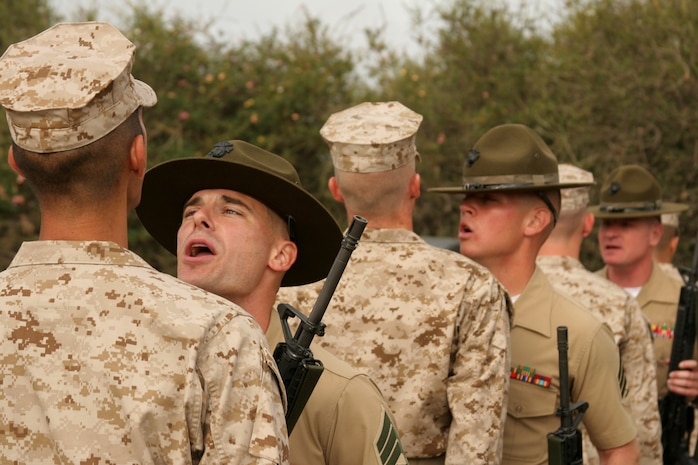 Drill instructors of Company A, 1st Recruit Training Battalion, inspect and question recruits during a senior drill instructor uniform inspection aboard Marine Corps Recruit Depot San Diego April 5.  Drill instructors create a high intensity high-stress environment to introduce the recruits to some of the elements found in combat.