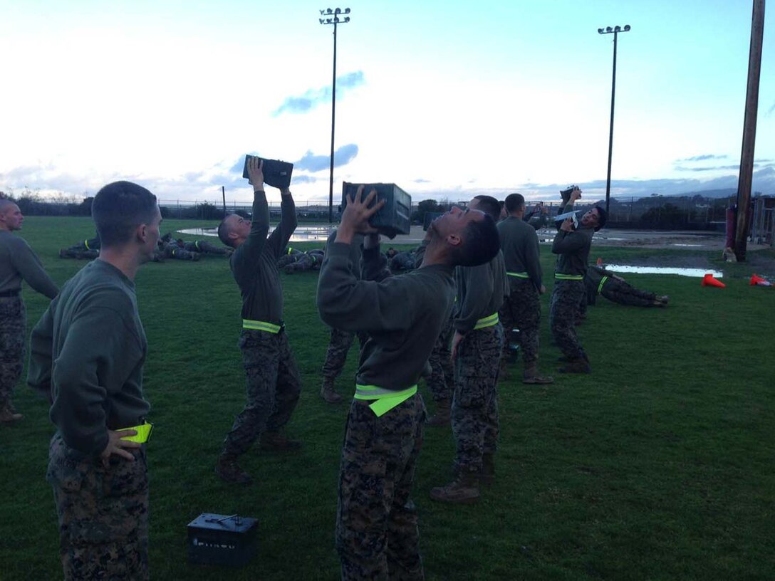 Corporals Leadership Summit 1-13 – Combat Conditioning – Corporals attending the course execute ammo can lifts while others perform plank exercises.

