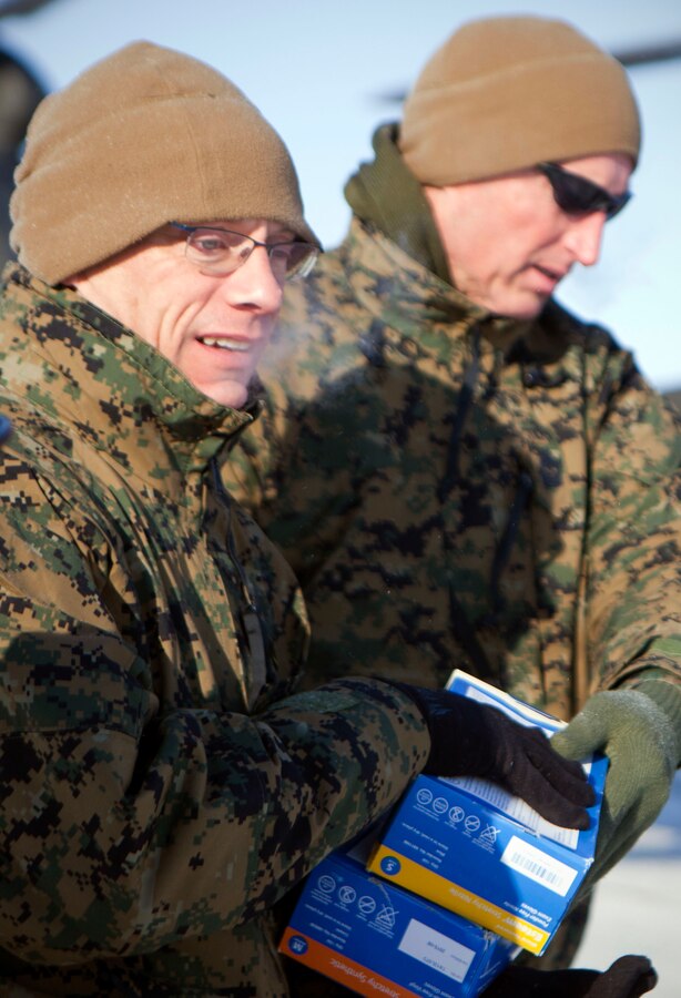 Brig. Gen. Roger R. Machut, the commanding general of 4th Marine Logistics Group, and Sgt. Maj. Richard Lewallen, the 4th MLG sergeant major, unload medical supplies from a National Guard UH-60 Black Hawk helicopter here, April 15. Machut flew aboard the Black Hawk to observe the unloading process in Deering and jumped in to help the service members in an austere Arctic environment. IRT Arctic Care is a multi-service humanitarian and training program focusing on enhancing the interoperability and capacity of U.S. forces in peacetime support operations, humanitarian assistance and disaster relief. The exercise is primarily a Reserve effort with Marine Forces Reserve taking the lead and receiving logistical and medical support from the National Guard, Army Reserve, Navy Reserve and Air Force Reserve. 