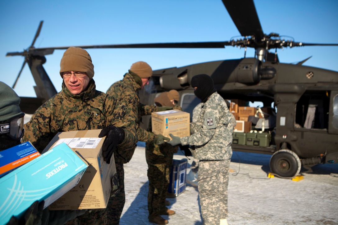 Brig. Gen. Roger R. Machut, the commanding general of 4th Marine Logistics Group, helps unload medical supplies from a National Guard UH-60 Black Hawk helicopter here, April 15. The medical supplies were flown to Deering, Alaska, one of 12 rural Alaskan villages assisted during the Innovative Readiness Training Arctic Care 2013. IRT Arctic Care is a multi-service humanitarian and training program focusing on enhancing the interoperability and capacity of U.S. forces in peacetime support operations, humanitarian assistance and disaster relief. The exercise is primarily a Reserve effort with Marine Forces Reserve taking the lead and receiving logistical and medical support from the National Guard, Army Reserve, Navy Reserve and Air Force Reserve.