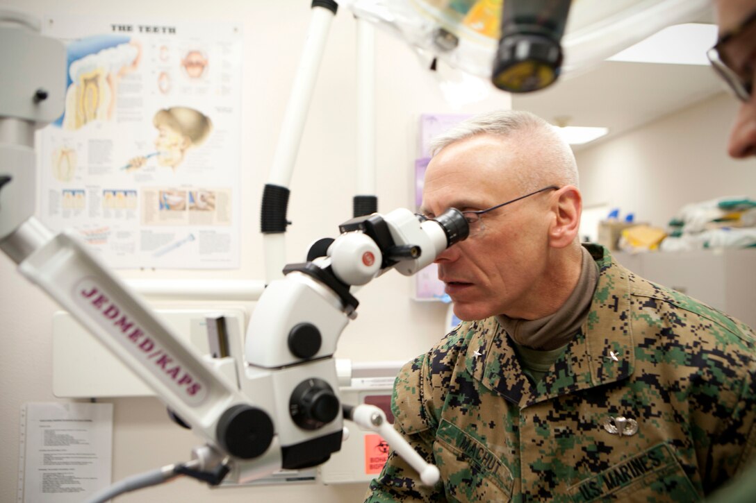 Brig. Gen. Roger R. Machut, the commanding general of 4th Marine Logistics Group, examines a surgical operation microscope used for the dental care provided by the service members of Innovative Readiness Training Arctic Care 2013, here, April 15. Machut toured the local medical facility where medical and dental care are being provided to the people of Kotzebue, one of 12 rural Alaskan villages assisted during the event. IRT Arctic Care is a multi-service humanitarian and training program focusing on enhancing the interoperability and capacity of U.S. forces in peacetime support operations, humanitarian assistance and disaster relief. The exercise is primarily a Reserve effort with Marine Forces Reserve taking the lead and receiving logistical and medical support from the National Guard, Army Reserve, Navy Reserve and Air Force Reserve. 