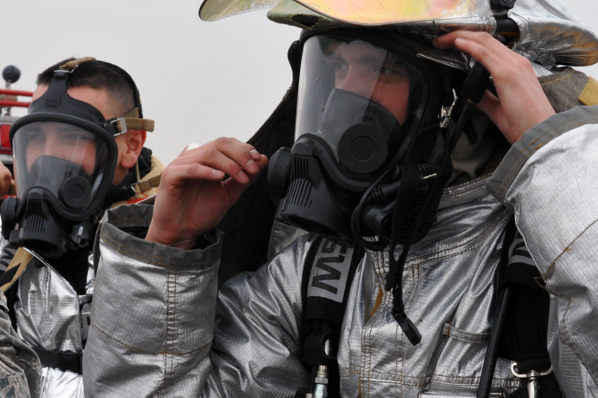 Airman 1st Class Frank Boniello and Senior Airman Drew Edwards, 51st Civil Engineer Squadron fire and emergency services flight firefighters, don their gear before participating in a jet-fuel fire training exercise at Camp Humphreys, Republic of Korea, April 17, 2013. The training was conducted with contaminated JP-8 fuel that was unfit for use in an aircraft and would be disposed of. (U.S. Air Force photo/Senior Airman Alexis Siekert)