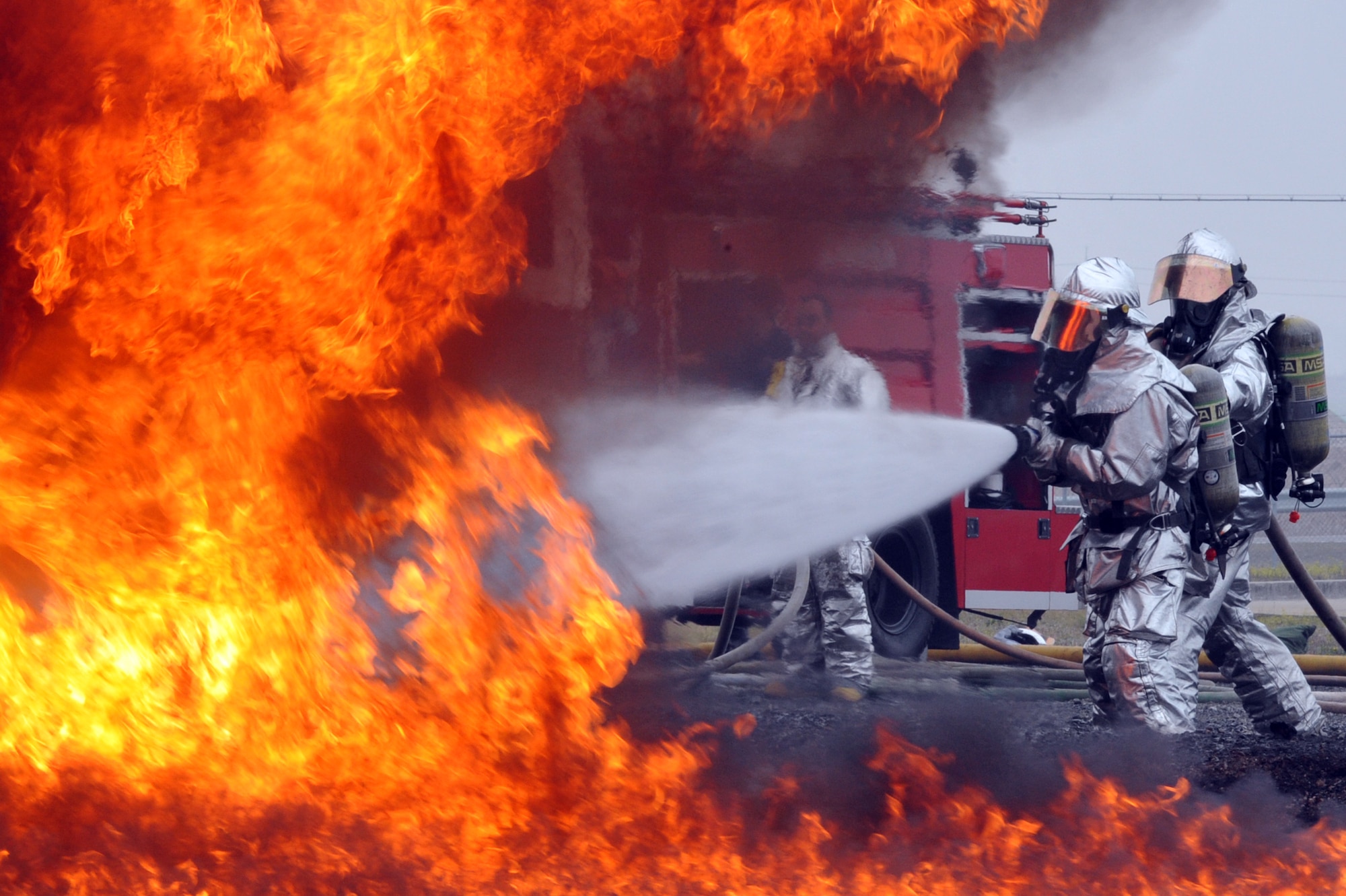 Staff Sgt. Travis Barrett and Senior Airman Jirmichael Ward, 51st Civil Engineer Squadron fire and emergency services flight firefighters, perform a fire extinguishment during a jet-fuel fire training exercise at Camp Humphreys, Republic of Korea, April 17, 2013. Training exercises like these give Airmen an accurate feel of an aircraft fire. (U.S. Air Force photo/Senior Airman Alexis Siekert)