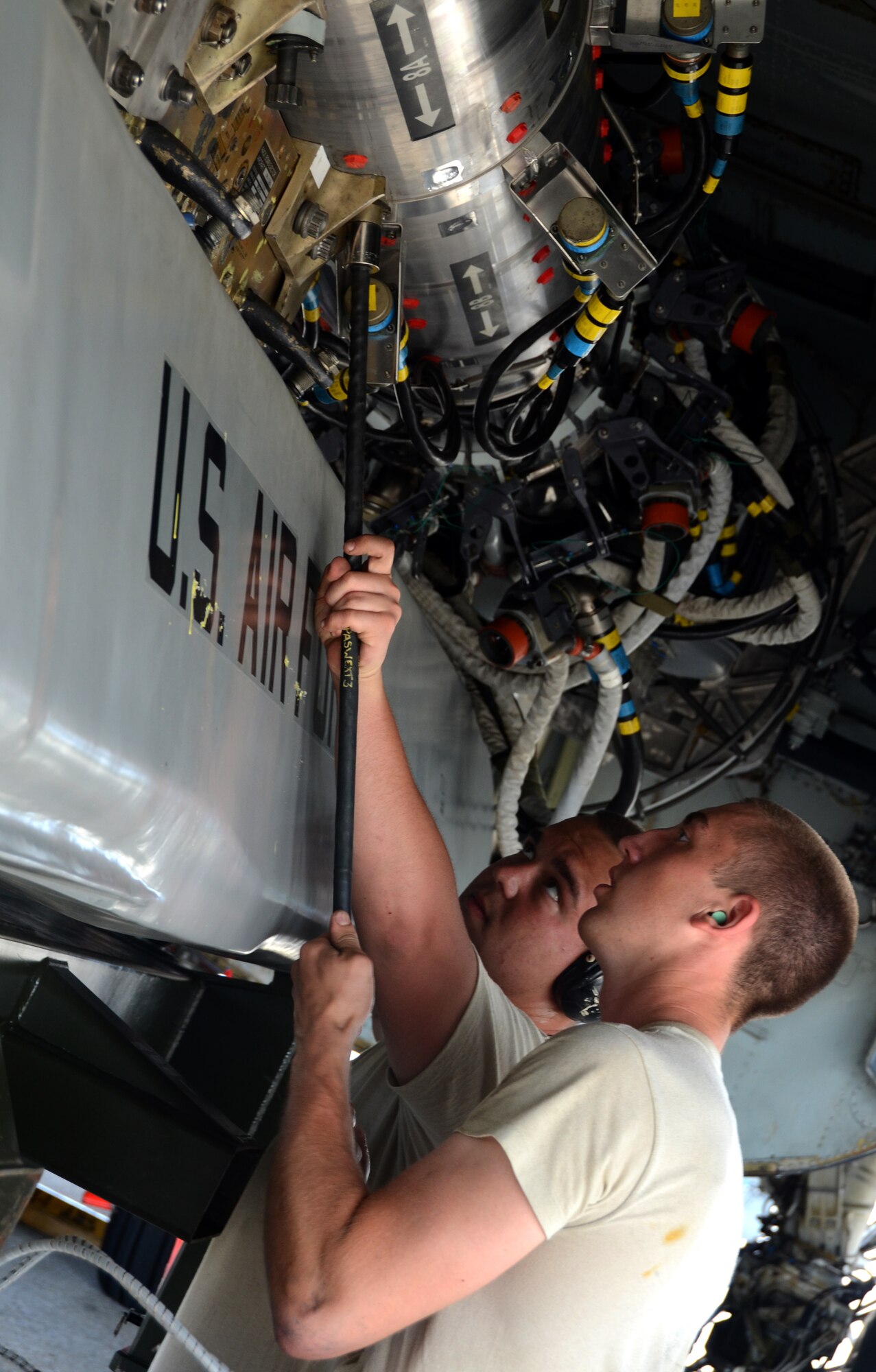 Airman 1st Class Adam Schaetzl (right) and Staff Sgt. Brody Bundy, 36th Expeditionary Aircraft Maintenance Squadron weapons load technicians, secure a training AGM-86C Conventional Air-Launched Cruise Missile inside the belly of a B-52 Stratofortress during a load demonstration at Andersen Air Force Base, Guam, April 16, 2013. All EAMUs deployed to Andersen have to pass a load inspection within 10 days of arrival as part of a U.S. Pacific Command requirement to ensure all tools and equipment are mission ready. Maintainers also obtain munitions-loading experience in both a training and tropical environment. (U.S. Air Force photo by Senior Airman Benjamin Wiseman/Released)