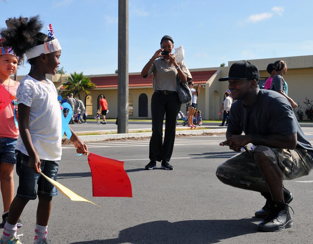 Tech. Sgt. Bryan Hawk, 36th Wing Legal Office civil law NCO in charge, smiles at his daughter during the Month of the Military Child parade at the child development center on Andersen Air Force Base, Guam, April 12, 2013. The Month of the Military Child was created by former Defense Secretary Caspar Weinberger to underscore the important role children play in the armed forces community. (U.S. Air Force photo by Airman 1st Class Adarius Petty/Released)