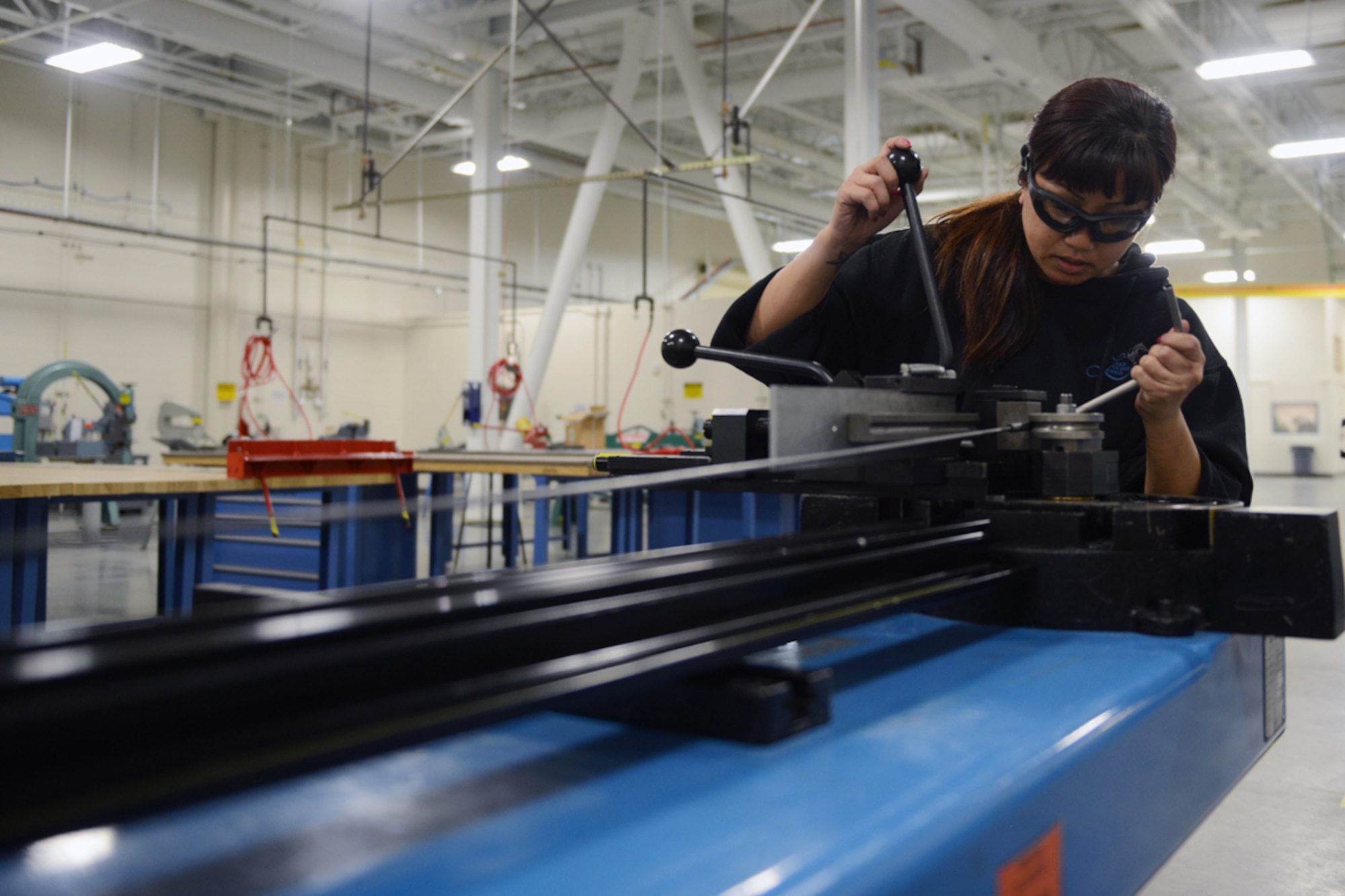 JOINT BASE ELMENDORF-RICHARDSON, Alaska -- Janny Dunlavey, aircraft structural maintenance craftsman for the 3rd maintenance squadron uses a tube bender to manufacture hydraulic lines for an aircraft at the Aircraft Structural Maintenace shop March 25. An aspect of the Aircraft Structural Maintenance Shop is to take damaged aircraft materials and refurbish them to thier original hull integrity. (U.S. Air Force photo/Airman Ty-Rico Lea)