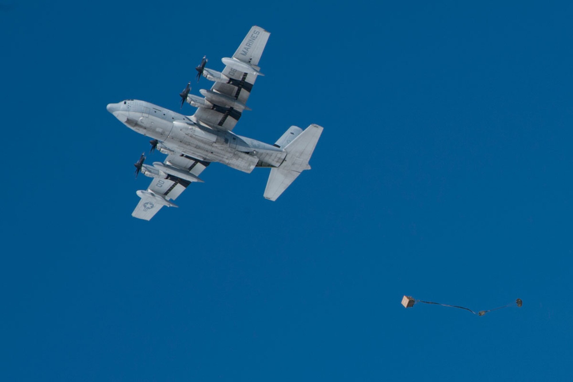 A palletized container, rigged by Soldiers of 4th Quartermaster Detachment, exits a Marine Aerial Refueler Transport Squadron 152 KC-130J Super Hercules, April 11 over Malamute Drop Zone April 11. (U.S. Air Force photo/Airman 1st Class Omari Bernard)