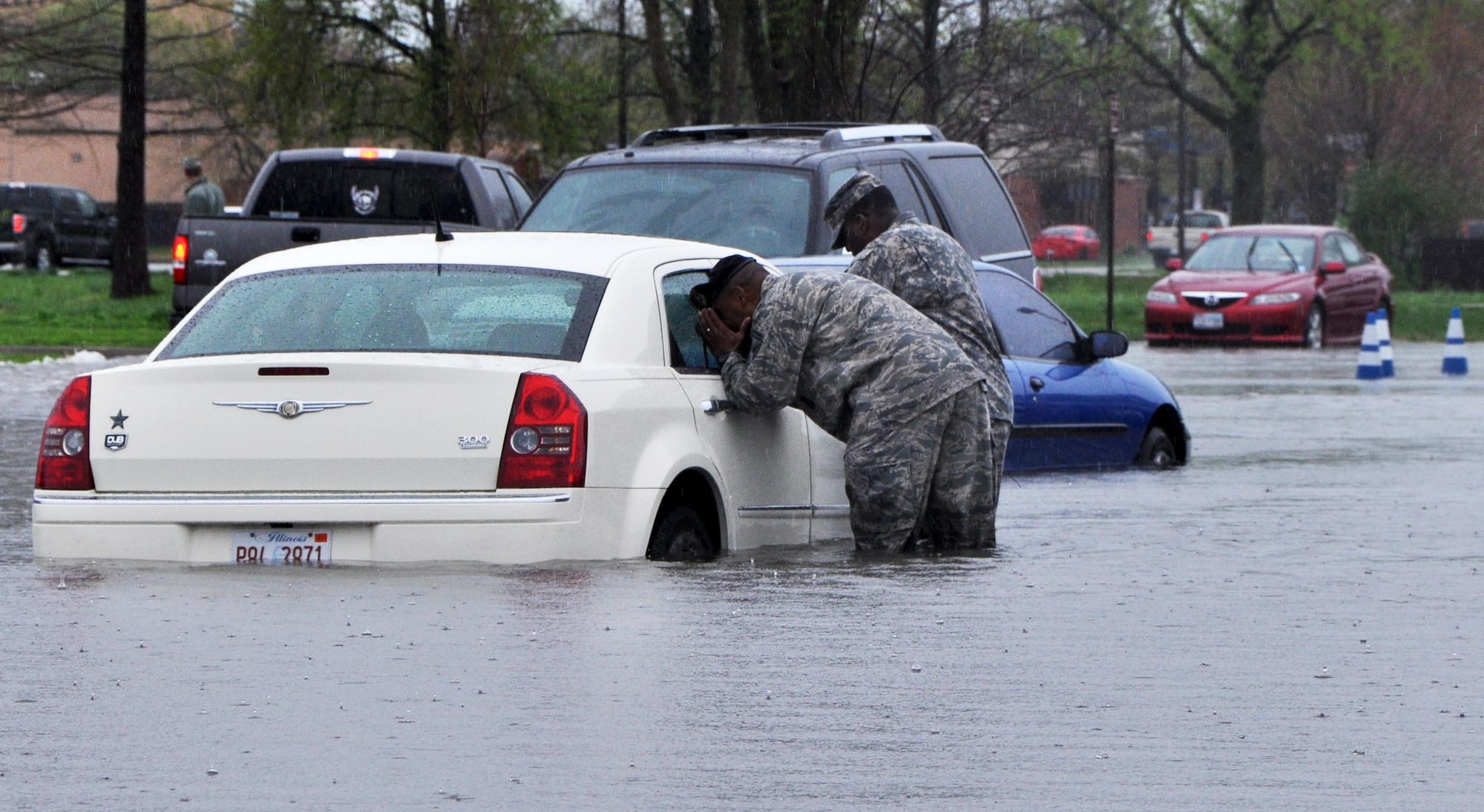 Servicemembers checked on vehicles at Scott AFB April 18, 2013 as 5.2 inches of rain fell in five hours. (U.S. Air Force photo/Airman Megan Friedl)