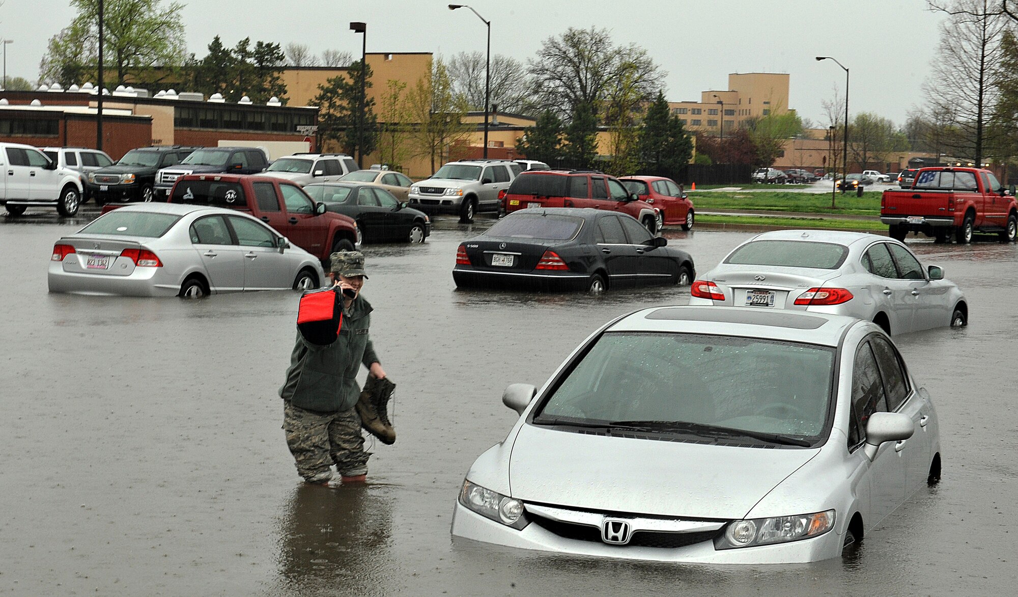 Workers from Bldg. 1900 found their cars swamped in the parking lot after heavy downpours at Scott Air Force Base, Ill., April. 18, 2013.  In total, 5.2 inches of rain deluged the low-lying areas of the base, forcing several roads to close and early release of some workers. Several Soldiers helped coworkers move their cars from the flooded areas.  (U.S. Air Force photo/Airman 1st Class Jaeda Waffer)