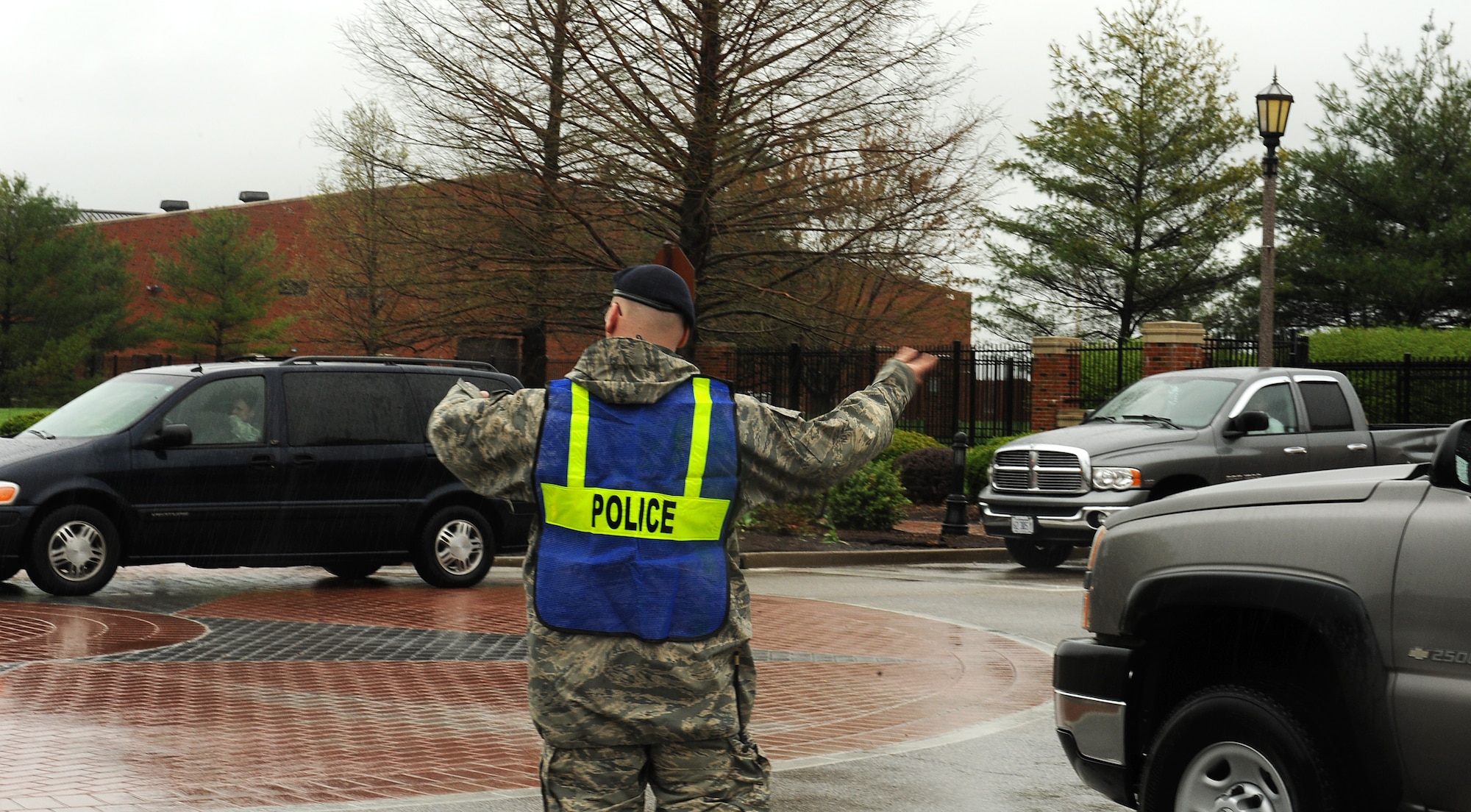 A 375th Security Forces Squadron patrolman directs traffic on Hangar Road after flooding closed several streets on Scott Air Force Base, Ill., April. 18, 2013. Severe weather dumped 5.2 inches of rain in five hours.  Base roads got congested when unit leaders granted early release of workers, due to deteriorating driving conditions. Roads were clear by 4 p.m. (U.S. Air Force photo/Airman 1st Class Jaeda Waffer)