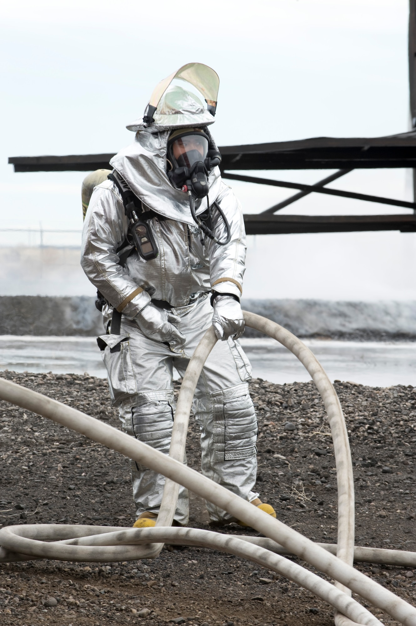 A firefighter retracts a fire hose after completing a live-fire training exercise at Mountain Home Air Force Base, Idaho, April 10, 2013. The 366th Civil Engineer Squadron fire department routinely practices their readiness and effectiveness as firefighters. (U.S. Air Force Photo/Airman 1st Class Malissa Lott)