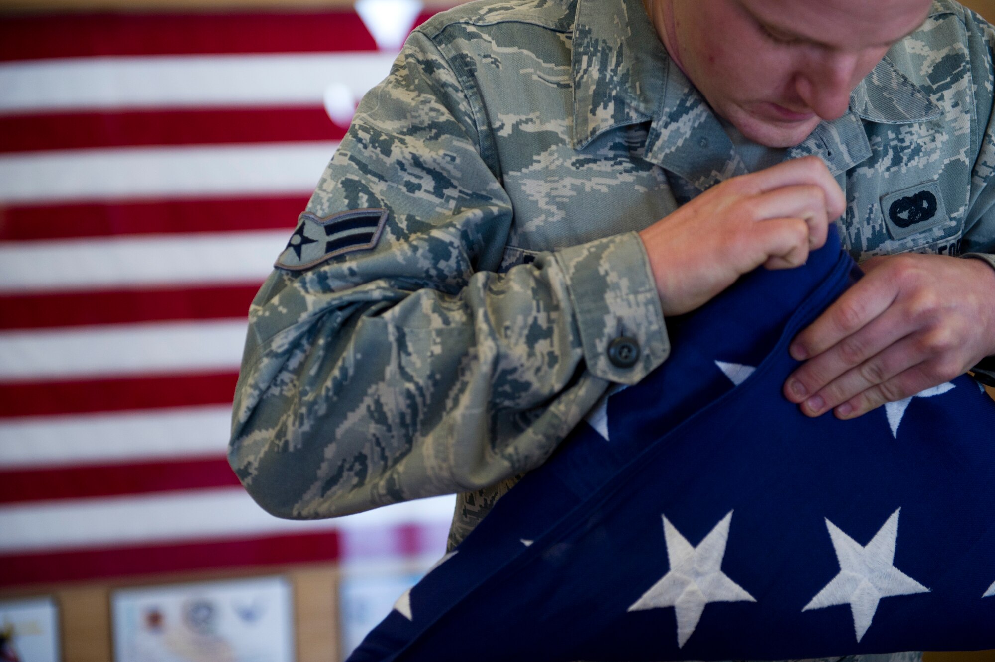 Airman 1st Class Adam Fairchild, a Steel Talons Honor Guard member, dresses a flag during a flag-folding sequence in the Heritage Center at Holloman Air Force Base, N.M., Feb. 20. The Steel Talons Honor Guard was created to honor fallen comrades and those who have served in any branch of the military. They do so by performing a variety of military and civilian ceremonies ranging from posting of the colors at a change of command to full military honors at an active-duty funeral. (U.S. Air Force photo by Senior Airman Joshua Turner/Released) 