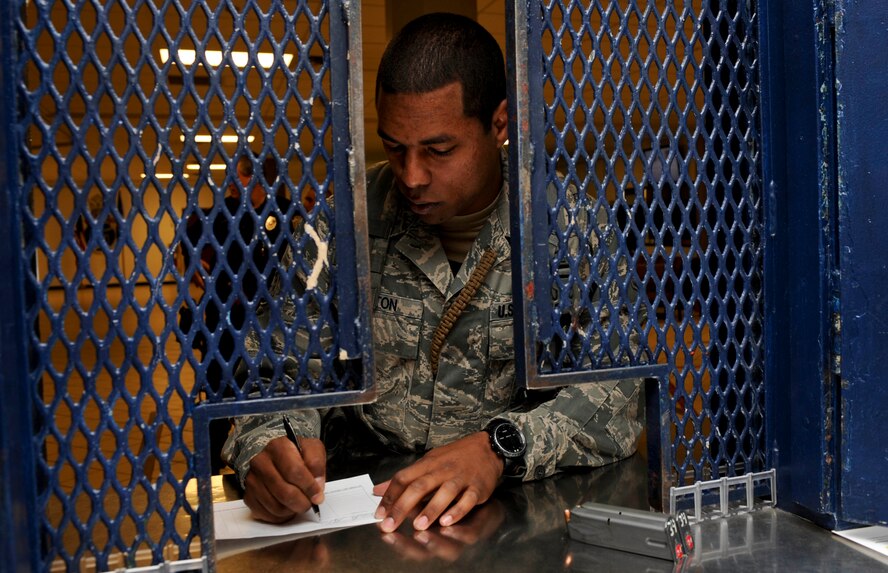 Staff Sgt. Alexander Alston, 28th Security Forces Squadron flight chief, signs out his weapon and gear from the security forces armory on Ellsworth Air Force Base, S.D., April 4, 2013. Each Airman must check in with the armory prior to and after each shift for equipment accountability of weapon issuance and ammunition. (U.S. Air Force photo by Airman 1st Class Anania Tekurio/Released)