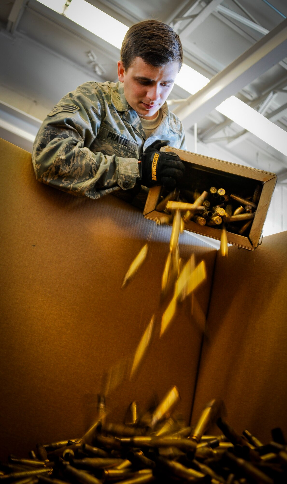 Senior Airman Shayne Pratte, 305th Maintenance Squadron Ammo Flight munitions crew chief, pours a box of spent .50-caliber casings into a sorting bin, at the MUNS (munitions) site here, April 5, 2013. Tucked away in a secluded area on the joint base, the ammo Airmen store, sort, inspect, handle and account for any ordinance needed for operations or training carried out by the Air Force and Marines. Pratte hails from Bristol, Conn. (U.S. Air Force photo by Airman 1st Class Ryan Throneberry/Released)