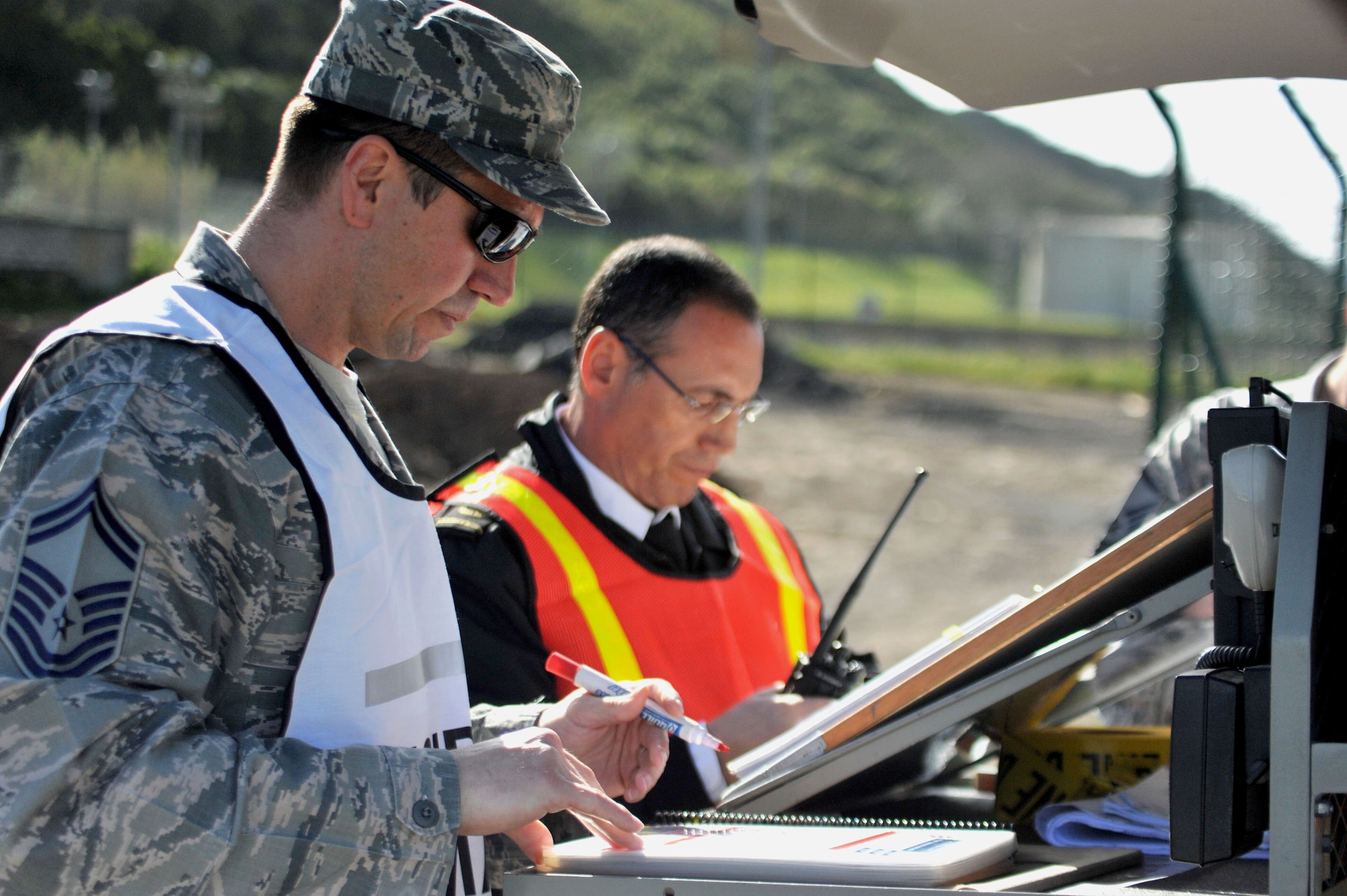 Senior Master Sgt. Brian Archuleta (left), 65th Civil Engineer Squadron fire department chief and Agostinho Simoes, fire department deputy chief set up a unified command center and plan their response following a simulated fuel spill during an exercise at the Lajes south tank farm, April 18, 2013, Praia da Vitoria, Azores. Lajes Field is the 2nd largest fuel store in the AF and the largest within USAFE. The 65th Air Base Wing regularly exercises scenarios testing Airmen’s ability to respond to crises, work with local authorities or account for personnel. (Photo by Guido Melo/released)