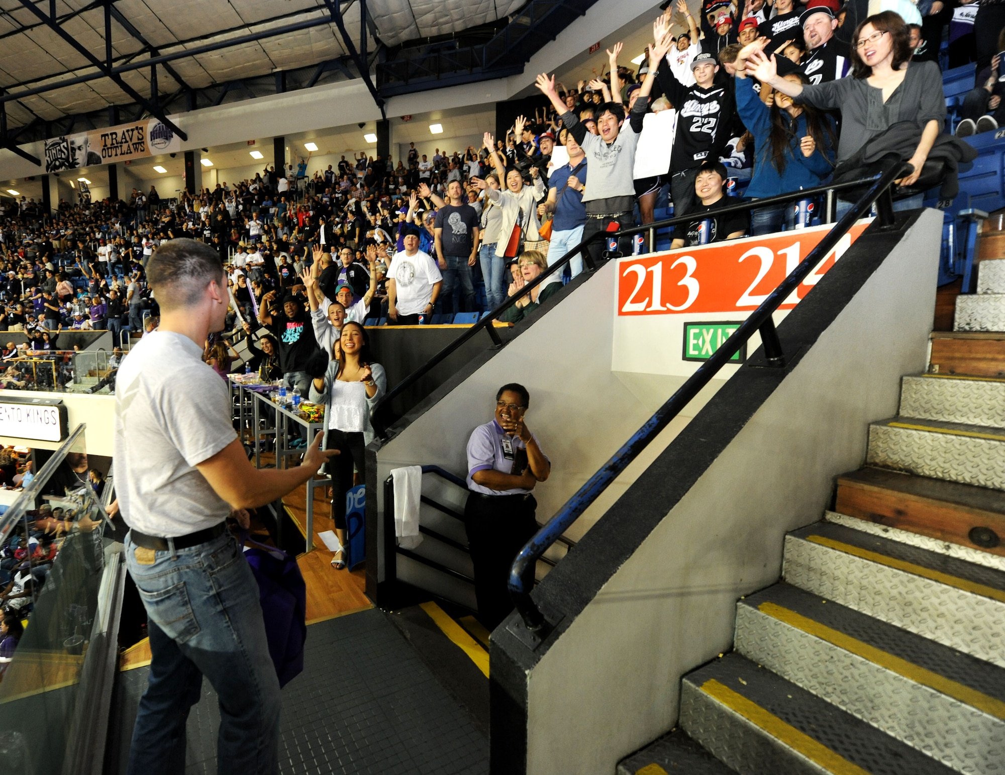 Airman 1st Class Charles Schatzle (left), 9th Civil Engineering Squadron firefighter, tosses a free T-shirt to a lucky fan at the Sleep Train Arena during the Sacramento Kings vs. L.A. Clippers game April 17, 2013. Schatzle and other Beale Airmen volunteered to aid the Kings’ staff during fan appreciation night. (U.S. Air Force photo by Airman 1st Class Bobby Cummings/Released)