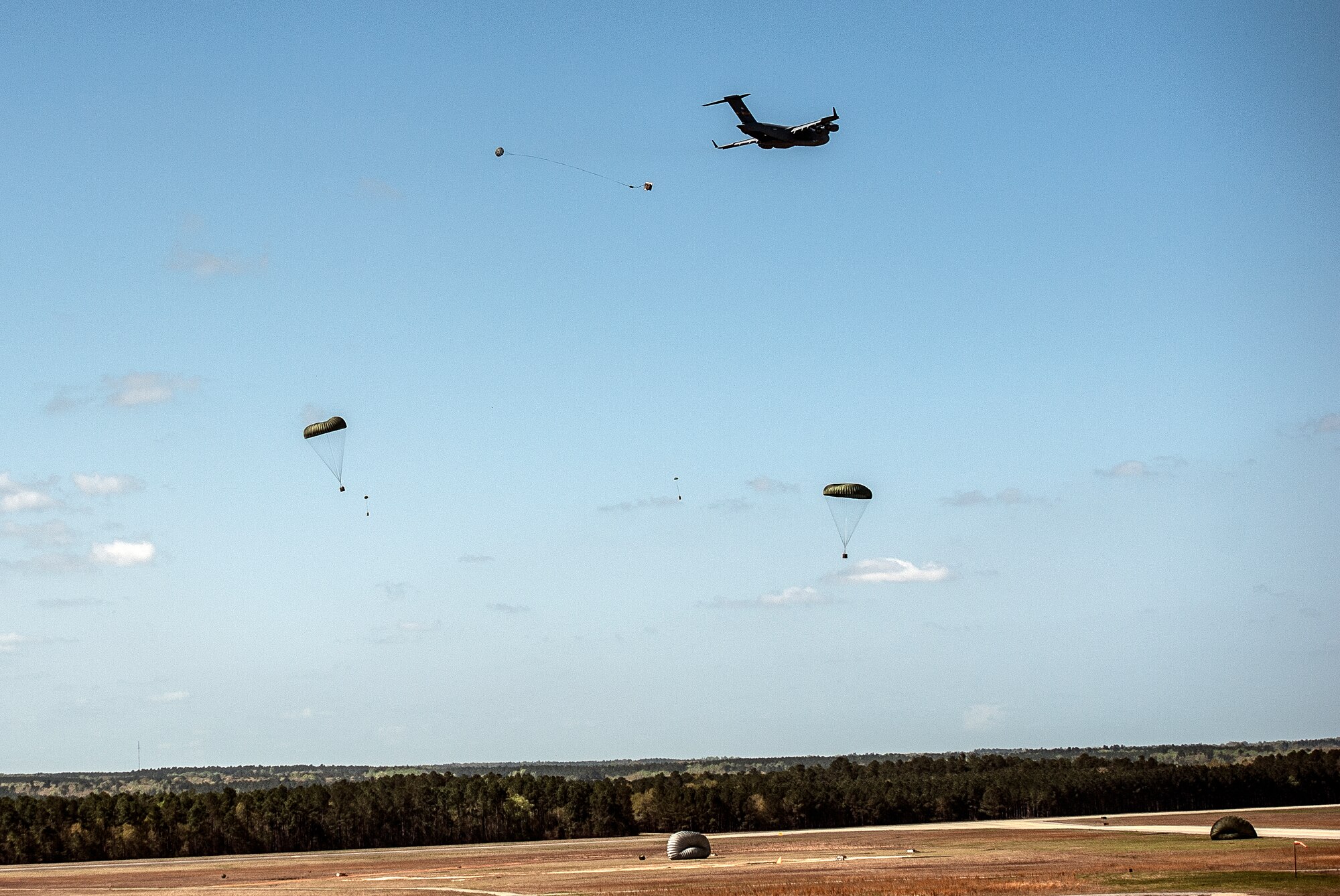 A C-17 Globemaster III performs an aerial drop over North Auxiliary Airfield during an exercise April 10, 2013, at Joint Base Charleston – Air Base, S.C. Thirteen C-17s participated in the exercise which included airdrops, aerial refueling and low-level tactical training. The exercise is a total-force effort with aircrews consisting of active-duty Airmen from the 437th Airlift Wing and 315th AW, and completed over 600 training requirements in a single day.  (U.S. Air Force photo/ Senior Airman Dennis Sloan)