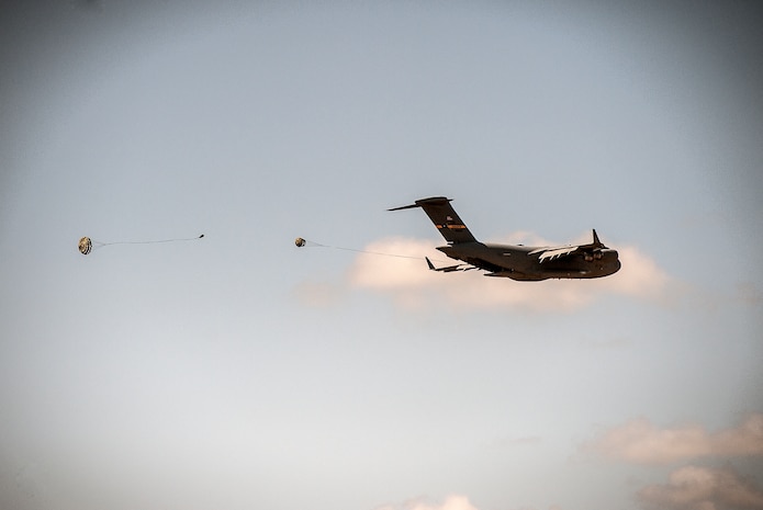 A C-17 Globemaster III performs an aerial drop over North Auxiliary Airfield during a exercise April 10, 2013, at Joint Base Charleston – Air Base, S.C. Thirteen C-17s participated in the exercise which included airdrops, aerial refueling and low-level tactical training. The exercise is a total-force effort with aircrews consisting of active-duty Airmen from the 437th Airlift Wing and 315th AW, and completed over 600 training requirements in a single day.  (U.S. Air Force photo/ Senior Airman Dennis Sloan)