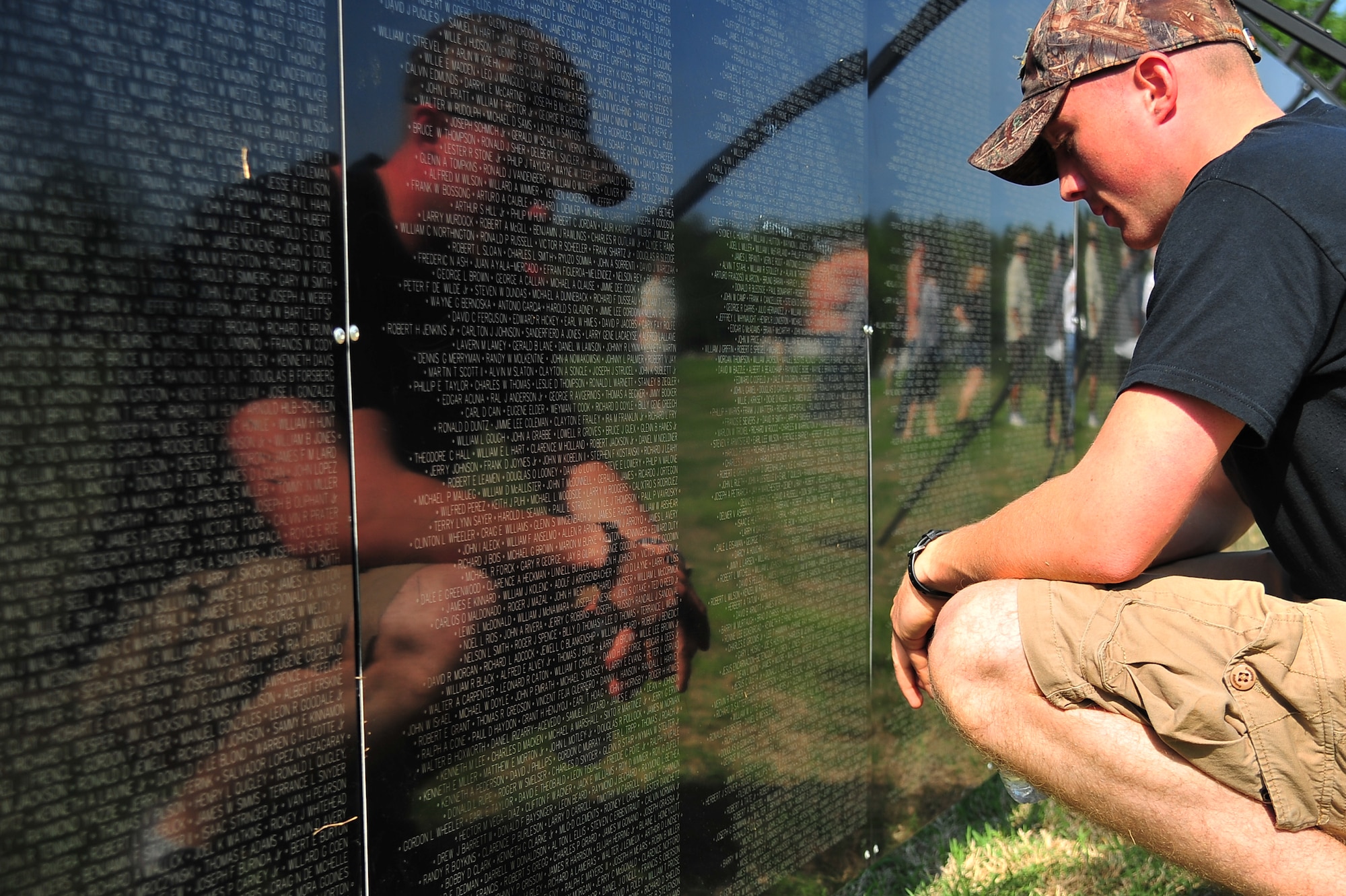 U.S. Air Force Airman 1st Class Neil Murphy, 4th Security Forces Squadron defender, reads the names of fallen veterans listed on the Vietnam Veterans Memorial Traveling Wall at the Wayne Community College campus in Goldsboro, N.C., April 17, 2013. The traveling wall was designed to honor the Vietnam veterans of all branches of the U.S. Armed Forces. (U.S. Air Force photo by Airman 1st Class Aubrey White/Released)