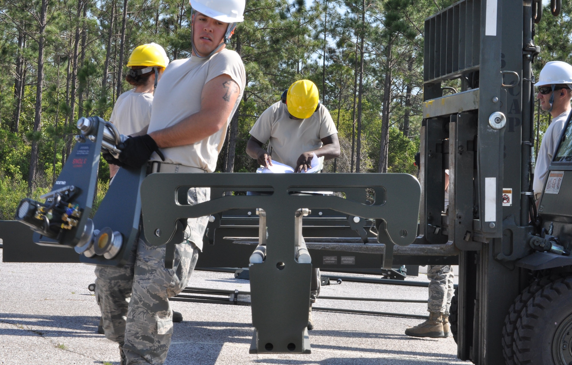Members of the 325th Maintenance Squadron build the Munitions Assembly Conveyor II for the first time on April 10 in the Alert Facility parking lot on Tyndall Air Force Base. The MAC II is a system that acts as an assembly line for munitions and speeds up the process of their build. (U.S. Air Force photo by Airman 1st Class Alex Echols)