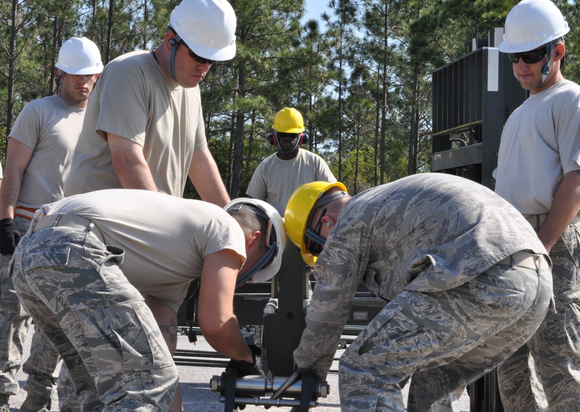 Members of the 325th Maintenance Squadron build the Munitions Assembly Conveyor II for the first time on April 10 in the Alert Facility parking lot on Tyndall Air Force Base. The MAC II is a system that acts as an assembly line for munitions and speeds up the process of their build. (U.S. Air Force photo by Airman 1st Class Alex Echols)
