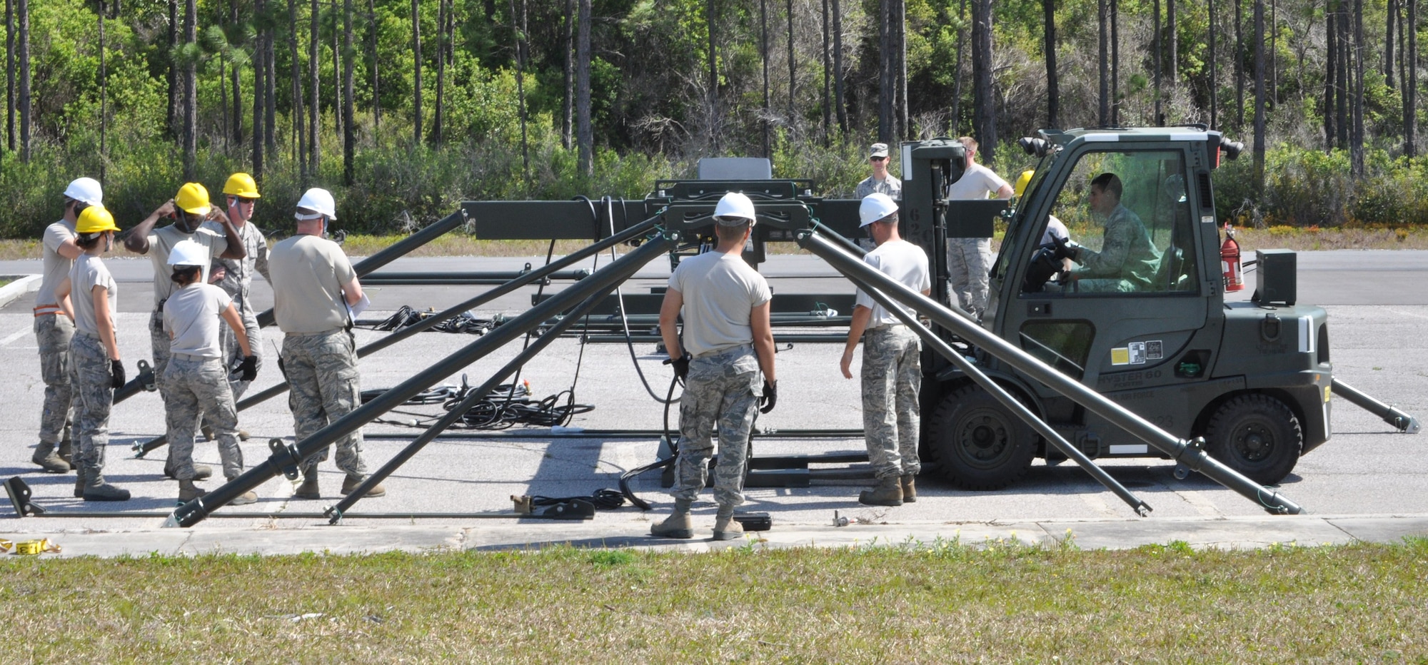 Members of the 325th Maintenance Squadron build the Munitions Assembly Conveyor II for the first time on April 10 in the Alert Facility parking lot on Tyndall Air Force Base. The MAC II is a system that acts as an assembly line for munitions and speeds up the process of their build. (U.S. Air Force photo by Airman 1st Class Alex Echols)