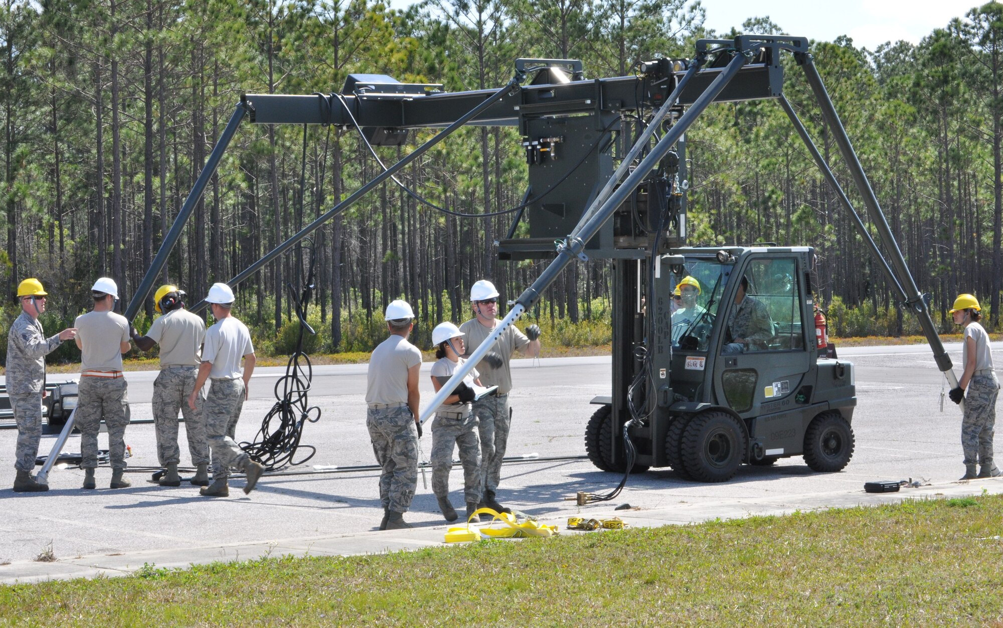 Members of the 325th Maintenance Squadron build the Munitions Assembly Conveyor II for the first time on April 10 in the Alert Facility parking lot on Tyndall Air Force Base. The MAC II is a system that acts as an assembly line for munitions and speeds up the process of their build. (U.S. Air Force photo by Airman 1st Class Alex Echols)