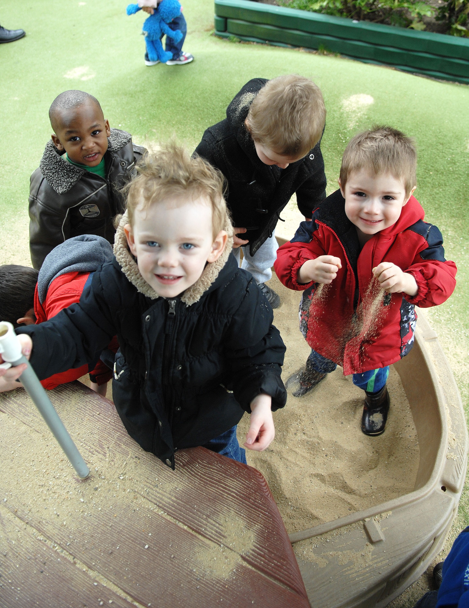 Team Mildenhall children play in a sandbox following a snack picnic April 17, 2013, at the Child Development Center on RAF Mildenhall, England. All classrooms and age groups at the CDC took part in the picnic. (U.S. Air Force photo by Airman 1st Class Dillon Johnston/Released)