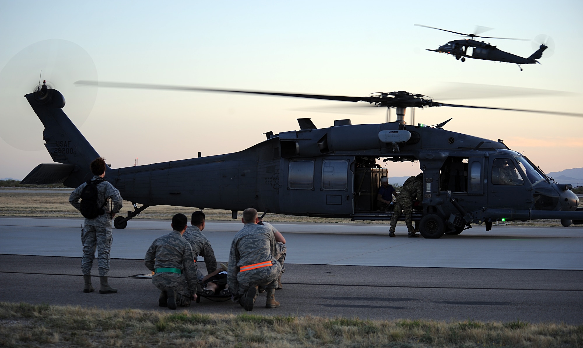 U.S. Air Force Airmen from the 355th Medical Group wait to load a victim of a simulated aircraft crash during Angel Thunder at Davis-Monthan Air Force Base, Ariz., April 13, 2013. Angel Thunder provides personnel recovery and combat search and rescue training for combat aircrews, pararescuemen, intelligence personnel, battle managers and joint search and rescue center personnel. (U.S. Air Force photo by Senior Airman Timothy Moore/Released)