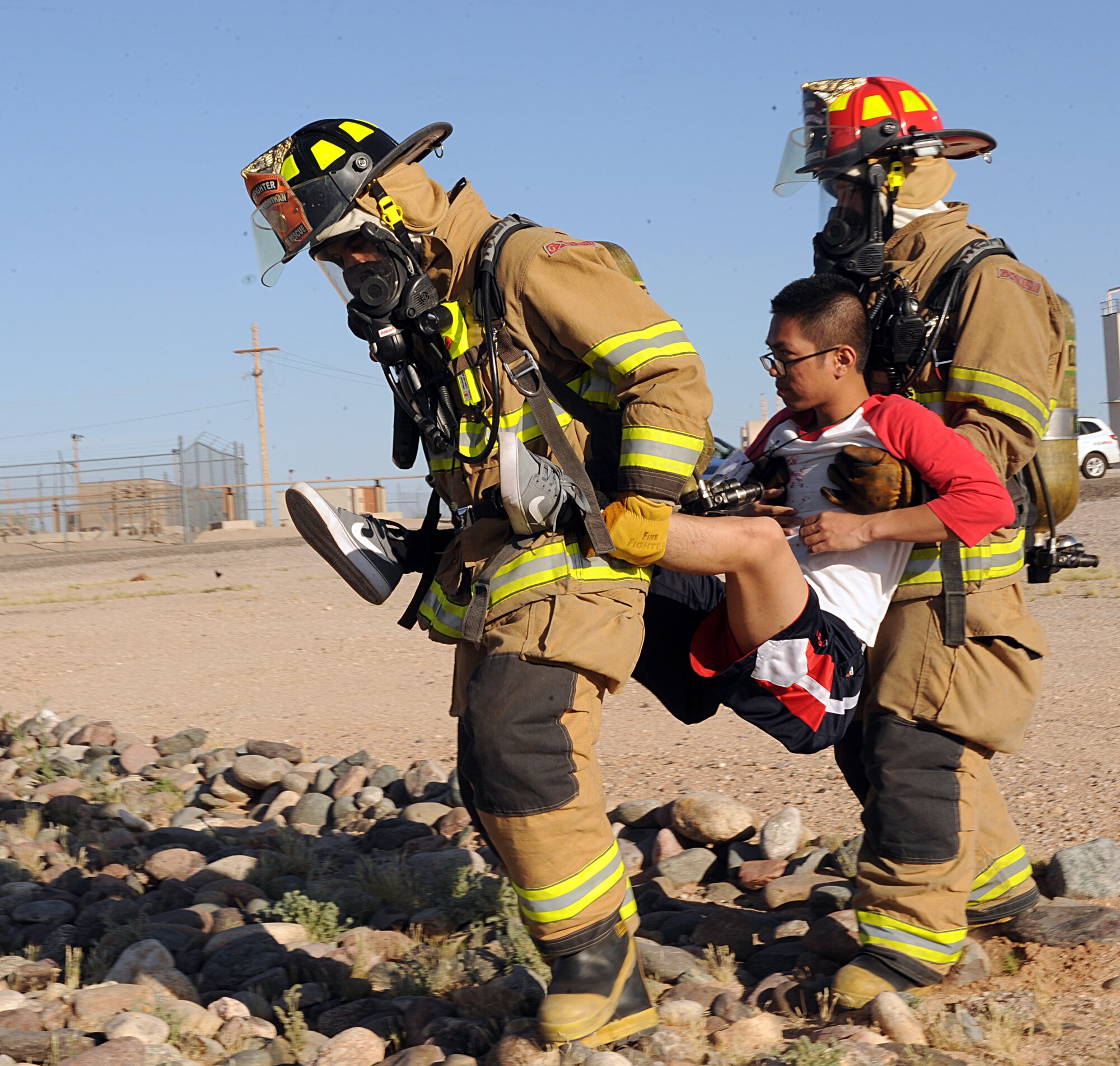 Firefighters from the 355th Civil Engineer Squadron carry Airman 1st Class Daniel Dulay, 355th Logistics Readiness Squadron, during the emergency medical exercise of Angel Thunder at Davis-Monthan Air Force Base, Ariz., April 13, 2013. Dulay participated in the exercise as a victim of simulated aircraft crash. (U.S. Air Force photo by Senior Airman Timothy Moore/Released)