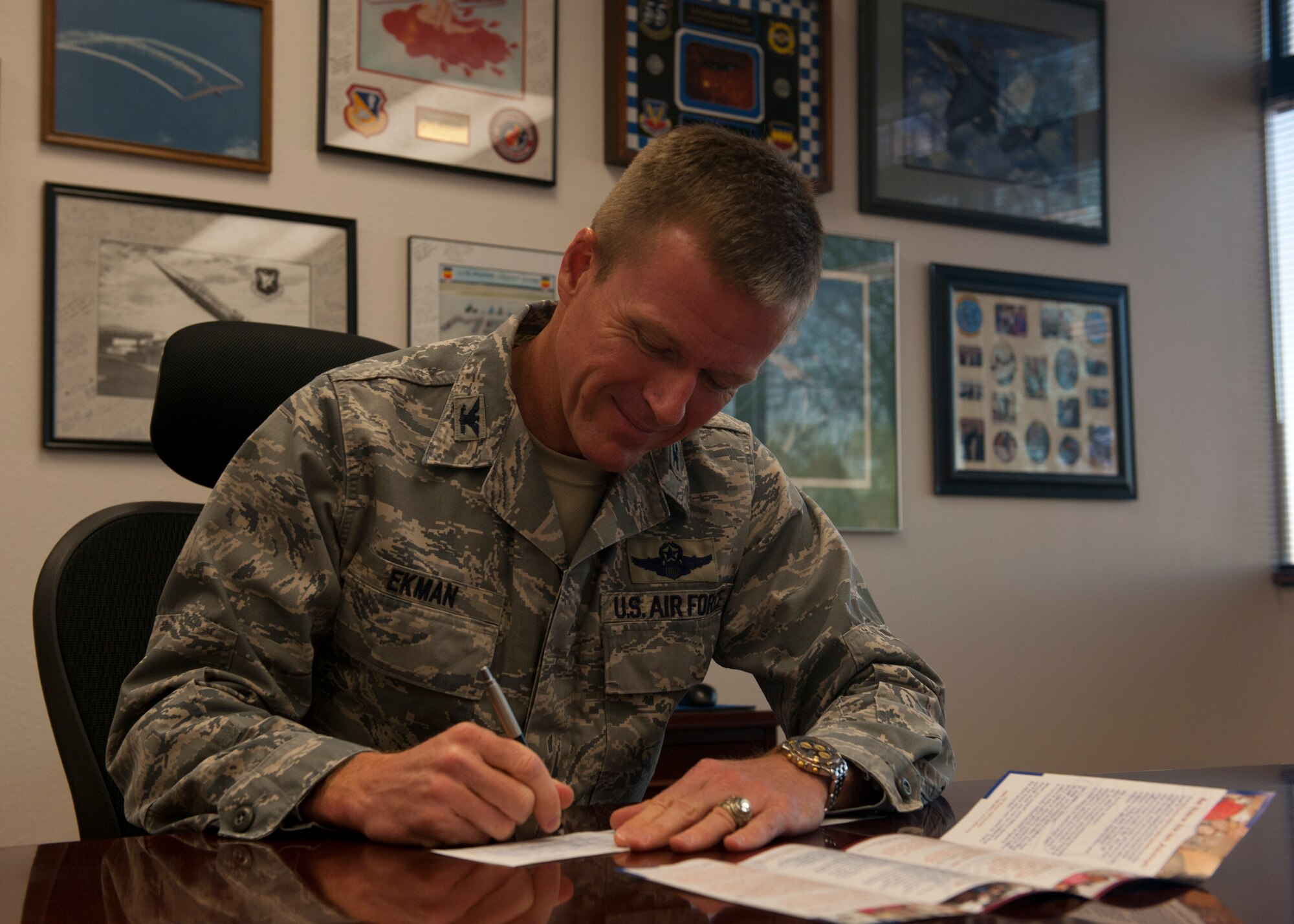 Colonel Kenneth Ekman, 49th Wing vice commander, signs a pledge for the 2013 Air Force Assistance Fund, at Holloman Air Force Base, N.M., April 17. The AFAF was established to raise funds for the charitable affiliates that provide support to U.S. Air Force families in need. (U.S. Air Force photo by Airman 1st Class Leah Murray/Released)