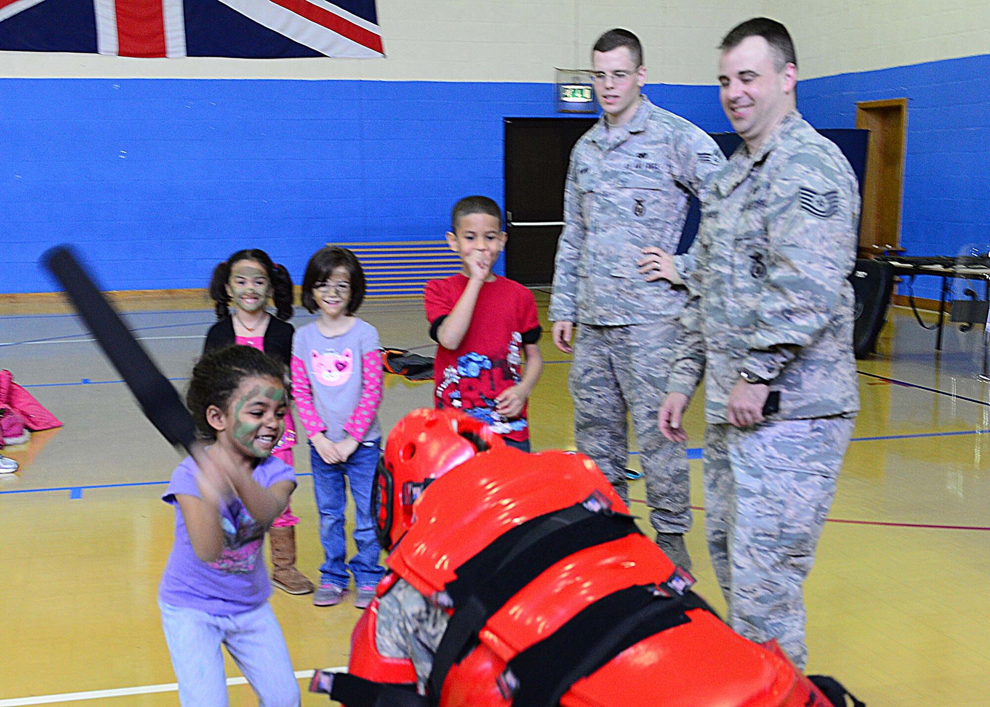 ROYAL AIR FORCE LAKENHEATH, England-- Ania Farley, daughter of Kayla Farley, 48th Force Support Squadron, swings a baton at the “red man suit” during security forces day at the RAF Lakenheath youth center April 12, 2013. The red man suit is used as baton training for security forces members, allowing them to learn the effective striking techniques. Security forces members visited the youth center to talk about their job. (U.S. Air Force photo by Staff Sgt. Stephanie Mancha)