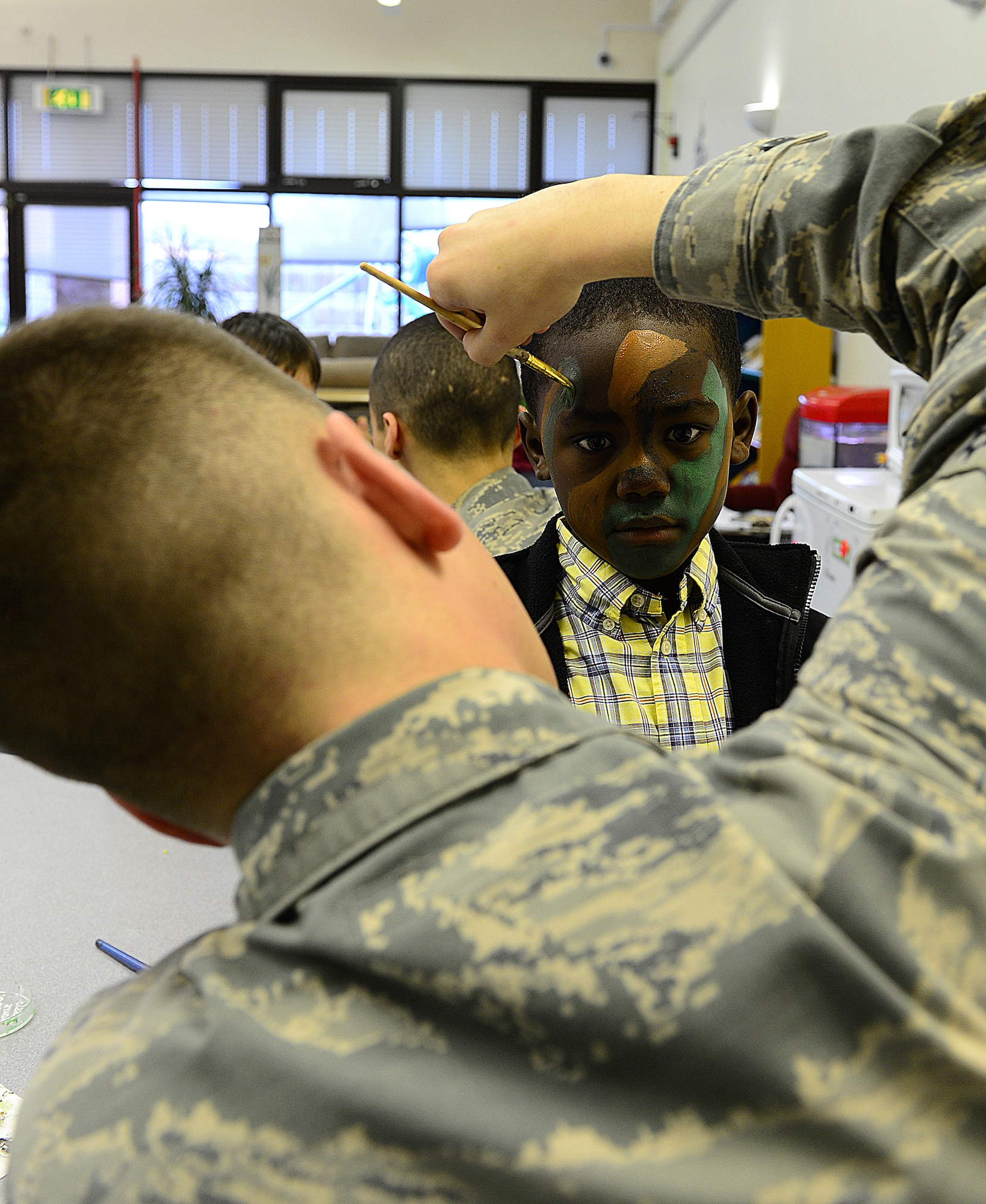 ROYAL AIR FORCE LAKENHEATH, England—Airman 1st Class Lucas Mallasch, 48th Security Forces Squadron response force member, puts camouflage face paint on Wade, son of Tech. Sgt. Tasha McFarlande, 748th Aircraft Maintenance Squadron, during security forces day at the RAF Lakenheath youth center, April 12, 2013. During spring break, children ages 5 through 12 were able to go “behind the scenes” of the post office, bowling alley and spend the day with security forces members. (U.S. Air Force photo by Staff Sgt. Stephanie Mancha)