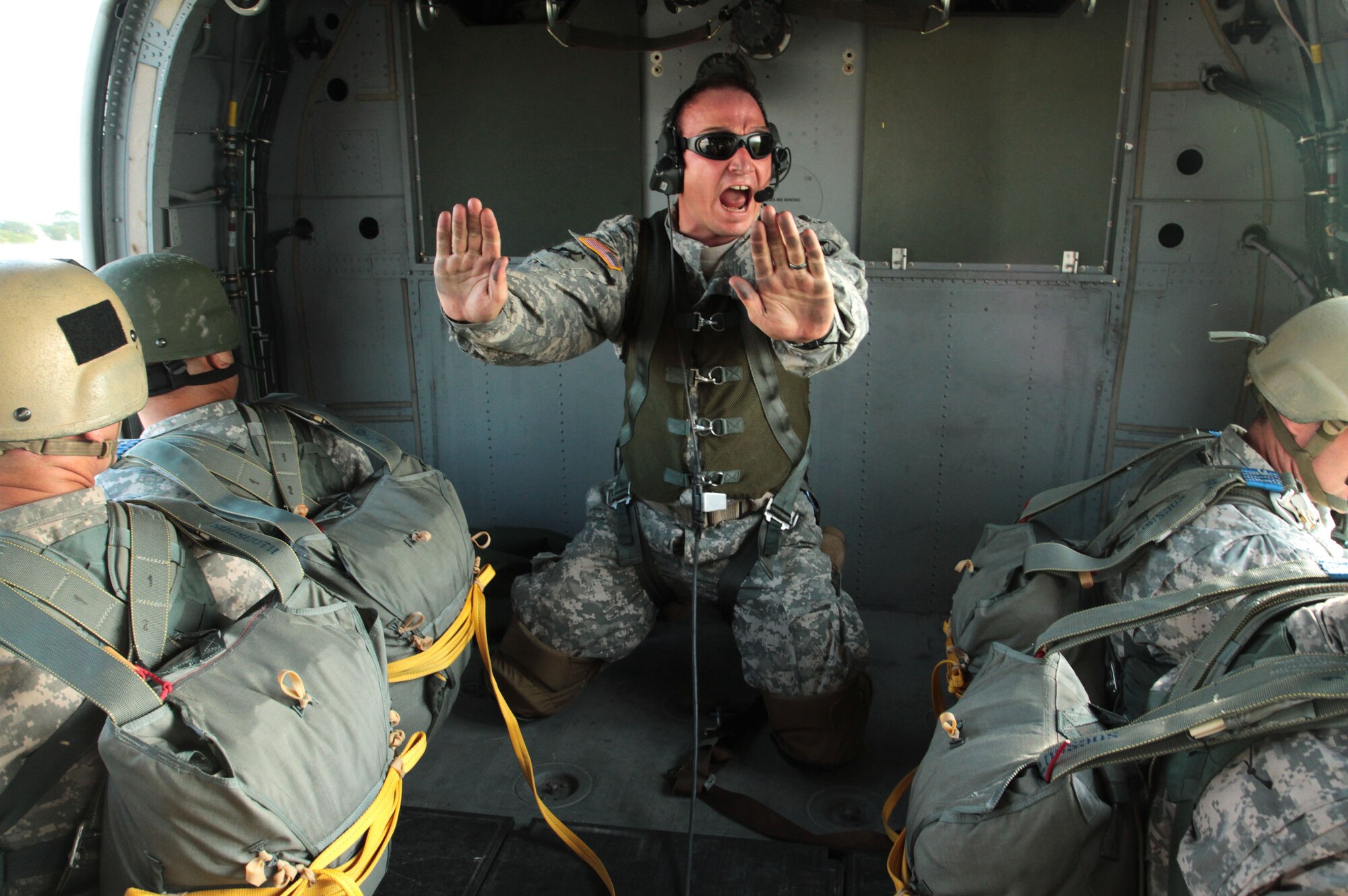 Army Sgt. 1st Class William Baker, a jumpmaster assigned to Special Operations Command South airborne operation, yells instructions to paratroopers before they jump out of a MH-60 helicopter during a rotary-wing airborne operation at Homestead Air Reserve Base, Fla., April 16. (U.S. Army photo by Sgt. 1st Class Alex Licea, SOCSOUTH Public Affairs/ Released)