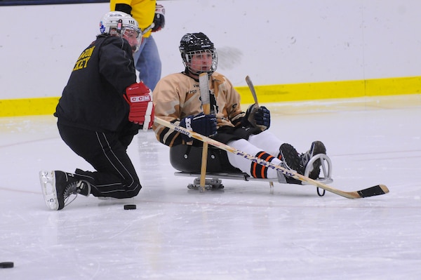 Mike McKenna (left), a project engineer with the U.S. Army Corps of Engineers, Fort Drum Field Office with one of the sled hockey team players.
