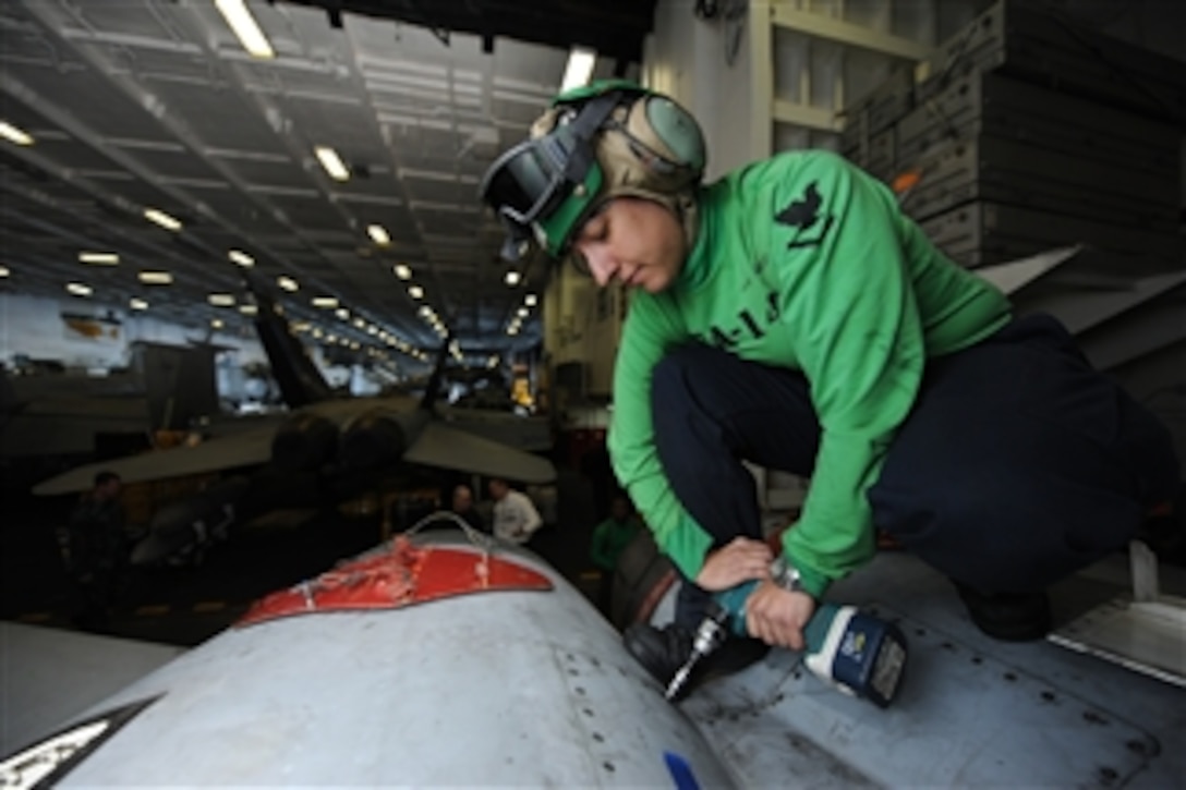 U.S. Navy Petty Officer 3rd Class Kathleen Caldwell performs maintenance on an F/A-18C Hornet in the hangar bay of the aircraft carrier USS Nimitz (CVN 68) as the ship operates in the Pacific Ocean on April 16, 2013.  Nimitz is underway for a sustainment training exercise in preparation for an upcoming deployment.  Caldwell is a Navy aviation structural mechanic.  