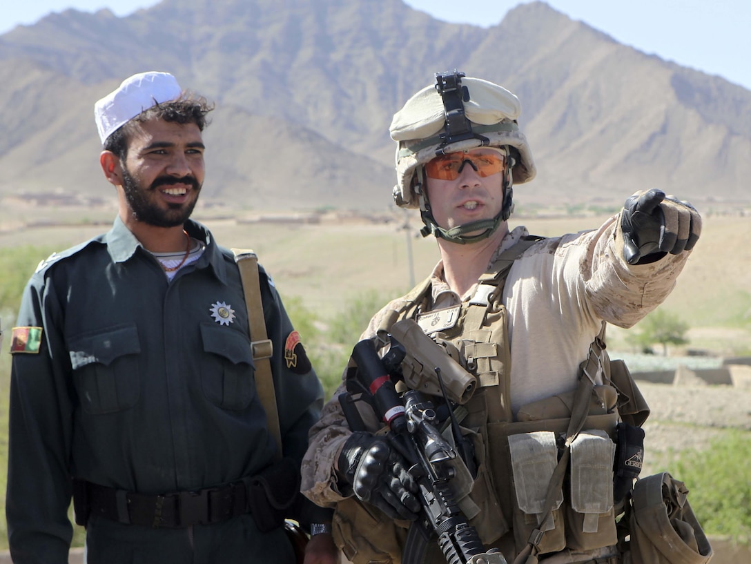 1st Lt. Sean Conway talks with road surveyors near Afghan Uniform Police Outpost Torioba, March 30. The surveyors were surveying for an ongoing road construction project on Route 611, the main road connecting Sangin with Kajaki. Conway is a member of the U.S. Marine-led Kajaki Police Advisor Team, the unit responsible for advising the Afghan Uniform Police. (Photo by Sgt. Bobby J. Yarbrough)