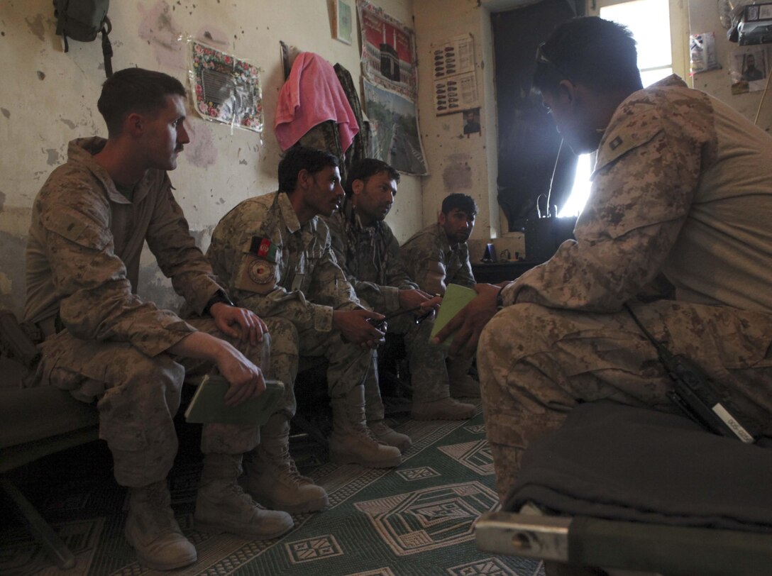 Members of the U.S. Marine-led Kajaki Police Advisor Team talk with the Afghan Uniform Police while visiting them at the Afghan Uniform Police Headquarters in Kajaki March 31. (Photo by Sgt. Bobby J. Yarbrough)