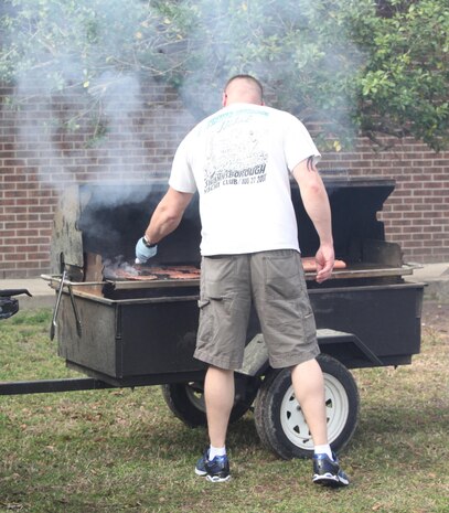 A Marine with Combat Logistics Battalion 2, 2nd Marine Logistics Group grills hamburgers and hotdogs during a field meet aboard Camp Lejeune, N.C., April 11, 2013. CLB-2 recently returned from a six-month deployment to Afghanistan and their leaders wanted to give the battalion a chance to relax before returning to work. (U.S. Photo by Lance Cpl. Shawn Valosin)