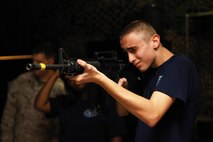 Brandon Pettit, a ninth grader and naval JROTC member with Northeast Guilford High School, prepares to fire in the standing position during a base tour aboard Camp Lejeune, N.C., March 25, 2013. The students visited the Basic Skills Training School to learn more about what Marines do while firing a weapon. 