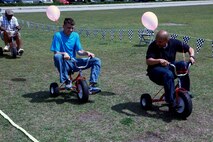 Servicemembers with Combat Logistics Battalion 6, 2nd Marine Logistics Group compete in a tricycle race during a family day at Soifert field aboard Camp Lejeune, N.C., April 17, 2013. Marines and sailors enjoyed the festivities after two months of non-stop training preparing for a future deployment to Afghanistan. 