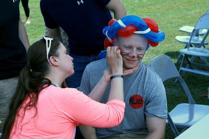 A Marine with Combat Logistics Battalion 6, 2nd Marine Logistics Group is getting his face painted as a mouse during a family day at Soifert field aboard Camp Lejeune, N.C., April 17, 2013. The family readiness officer with the battalion plans to host events like this every month for the servicemember’s families while the Marines and sailors are deployed to Afghanistan. 