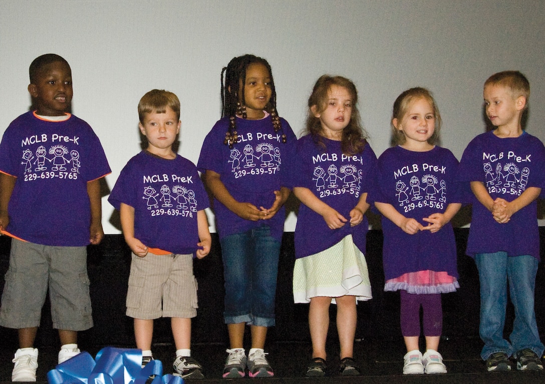 Children from the Child Development Center sing songs during the Child Abuse Awareness Month Proclamation ceremony held April 9 at the Base Theater, here.
