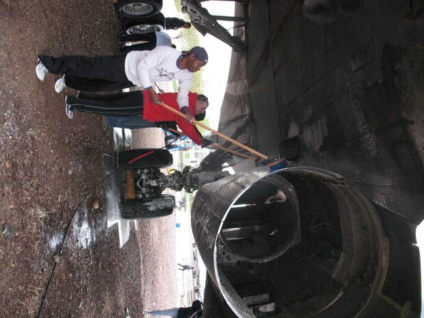 Senior Master Sgt. Kaci Duhart (left) and Maj. Donald Tasker wash the undercarriage of a B-1 Lancer static display April 13 at the Hill Aerospace Museum. Members of the 75th Comptroller Squadron gathered to clean and maintain the static display in accordance with the museum's Adopt-a-Plane program. (Photo by Mary Lou Gorny)