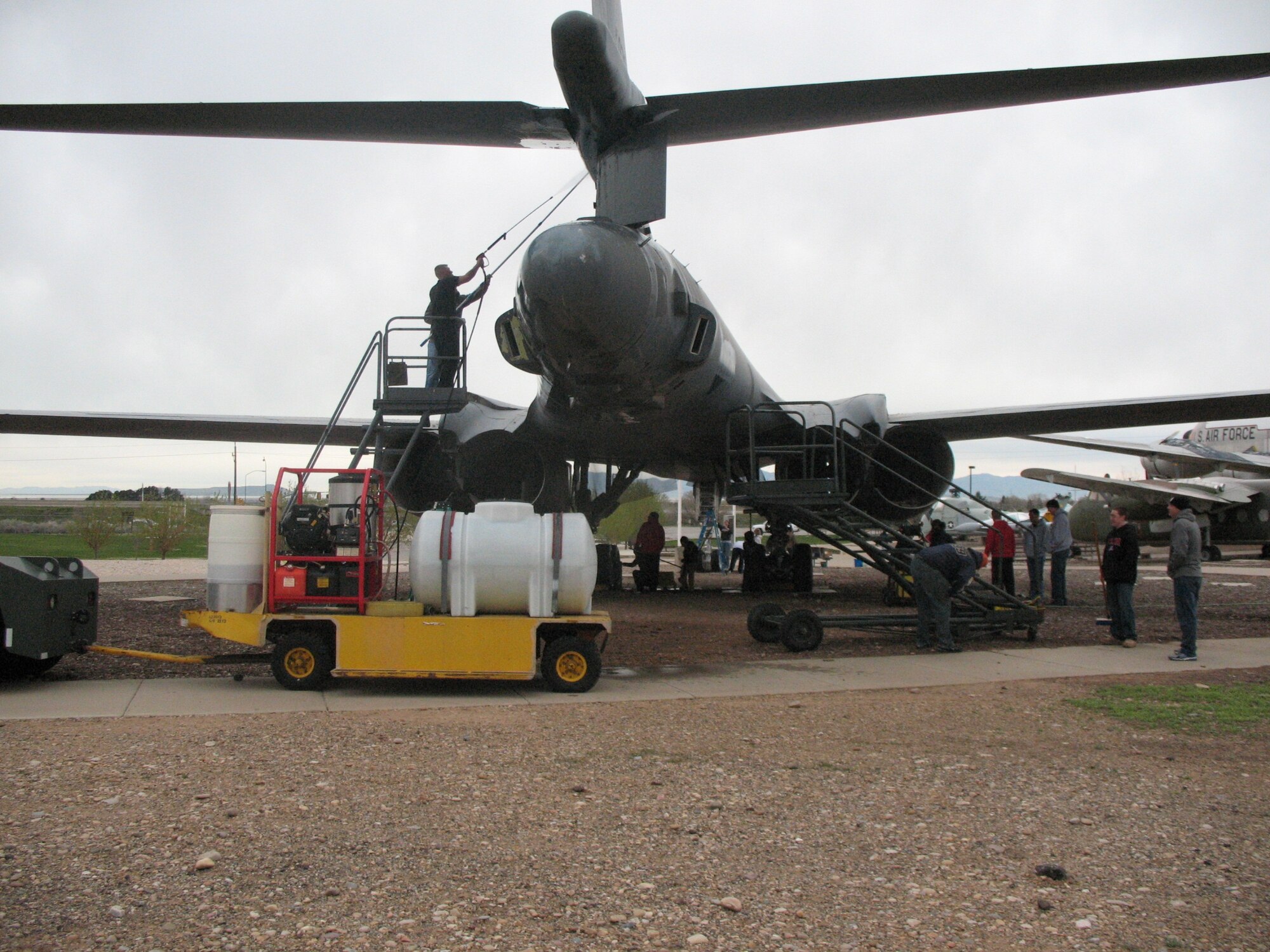 A high pressure sprayer cart sits behind a static display of a B-1 Lancer at the Hill Aerospace Museum while members of the 75th Comptroller Squadron evaluate what cleaning needs to be done April 13. Members of the squadron gathered to clean and maintain the static display in accordance with the museum's Adopt-a-Plane program. (Photo by Mary Lou Gorny) 