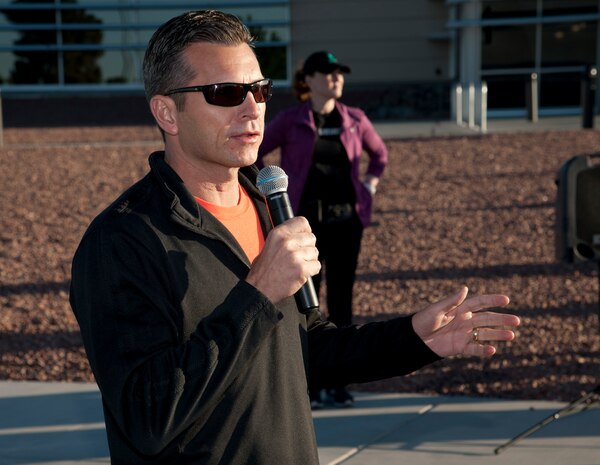 Col. Barry Cornish, 99th Air Base Wing commander, delivers opening remarks before the start of the Survive and Thrive 5-kilometer  run April 19, 2013, at Nellis Air Force Base, Nev. The event was coordinated by the sexual assault response coordinator, mental health, and the Warrior Fitness Center to promote mental wellness and wingman ship. (U.S. Air Force photo by Master Sgt. Jason W. Edwards)