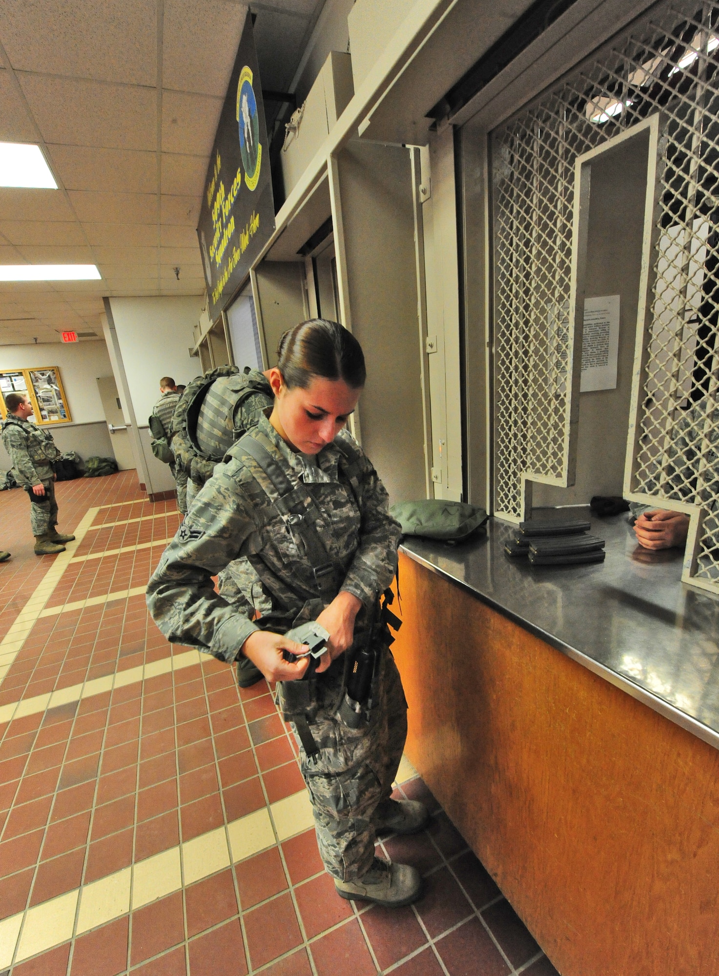 Airman 1st Class Grace Murphy, 509th Security Forces Squadron response force member, stores an M4 carbine magazine while receiving equipment from the armory at Whiteman Air Force Base, Mo., March 25, 2013. Members working in the armory ensure Airmen working on security forces posts have the weapons and ammunitions necessary to accomplish their mission. (U.S. Air Force photo by Staff Sgt. Nick Wilson/Released)